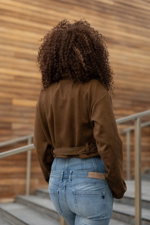 Tył dopasowanej brązowej ramoneski z ekozamszu na modelce. Wiosenna kurtka zamszowa bez ocieplenia, idealna na okres przejściowy.