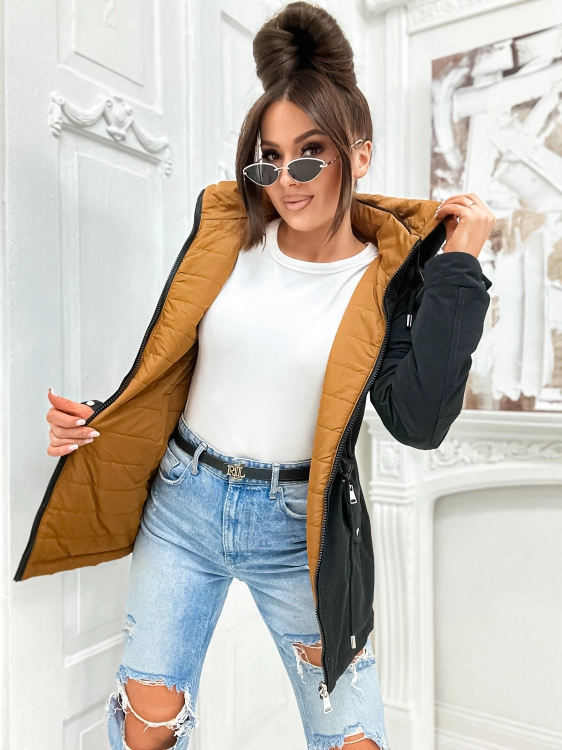 Modelka w czarnej wiosennje parce w stylizacji z jasnymi jeansami.